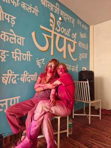 two women dressed in pink sitting on a bench at The Pink Nest - Backpackers Abode in Jaipur