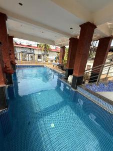 a large swimming pool with blue tiles in a building at Sportsman beach hotel in Calangute