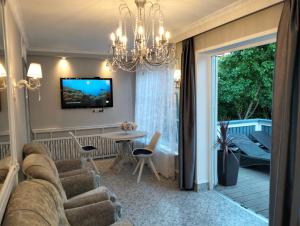 a living room with a couch and a chandelier at Apartment Sonata in Jūrmala