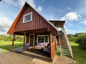 a tiny house with a porch and a staircase at Diby Kämping saunamaja numbritoad in Diibi