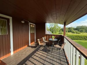 a porch with a table and chairs on a deck at Diby Kämping saunamaja numbritoad in Diibi +11 photos