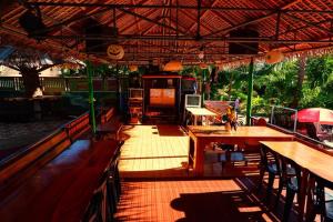 an outdoor restaurant with wooden tables and chairs at BuenaMaria Mountain Resort in Puerto Galera