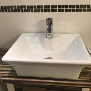 lavabo blanco con grifo en el baño en The Lodge en Kings Lynn