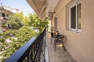 ein Balkon mit Tisch und Stühlen an einem Gebäude in der Unterkunft TReverie Stay -Modern 3BR Apartment for Families & Friends in Thessaloniki