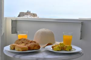 a table with two plates of pastries and two glasses of orange juice at Catsalos Studios in Pera Gyalos