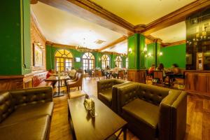 um restaurante com paredes verdes e sofás e mesas de couro em The Steuart by Citrus em Colombo