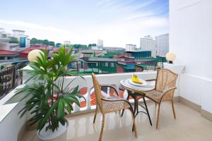a balcony with a table and chairs and a window at Hanoi Spoon Boutique Hotel in Hanoi