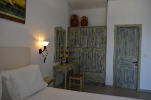 a bedroom with a bed and a table and some wooden cabinets at Catsalos Studios in Pera Gyalos