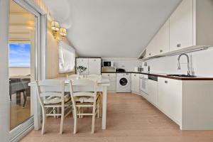 a kitchen with white cabinets and a table and chairs at Boutique Hotel Oasi in Pula