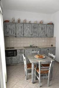 a kitchen with a table with chairs and a sink at Catsalos Studios in Pera Gyalos +4 photos