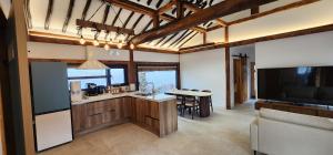 a kitchen and dining room with a table and a television at 전주한옥마을 자하연해랑 in Jeonju
