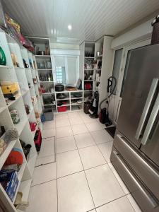 a kitchen with a refrigerator and a tiled floor at Villa Marie Suzon - Belle propriété pour 16 personnes à 5 mn de la Hume in Gujan-Mestras