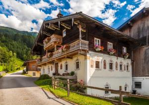 a house in the mountains with flowers on the balconies at Ferienwohnung Örgenbauer in Saalfelden am Steinernen Meer