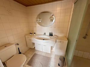 a bathroom with a sink and a toilet and a mirror at geräumiges Monteurapartment 2 in Bensheim mit Parkplatz in Bensheim