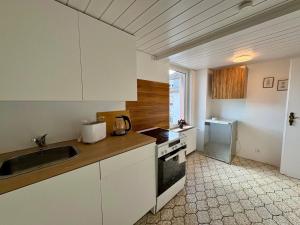a kitchen with white cabinets and a sink at geräumiges Monteurapartment 2 in Bensheim mit Parkplatz in Bensheim +18 photos