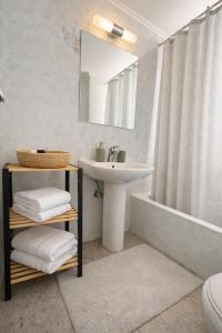 a bathroom with a sink and a mirror and a tub at Aurora Apartments in Mytilene +28 photos