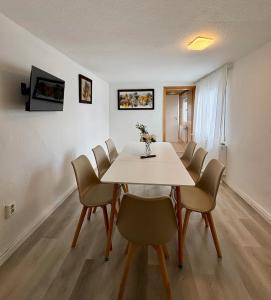 a dining room with a white table and chairs at geräumiges Monteurapartment 2 in Bensheim mit Parkplatz in Bensheim