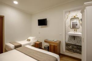 a hotel room with two beds and a sink at Hotel Forte in Rome