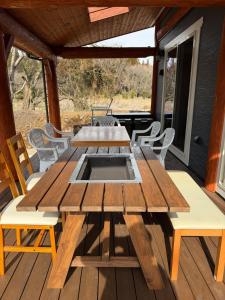 a wooden table and chairs on a deck at Villa Aso Otohime in Uchinomaki