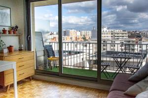a room with a balcony with a view of a city at Studio avec balcon Centre Ville in Montreuil