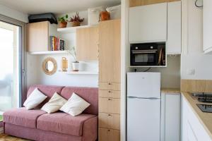 a living room with a pink couch in a kitchen at Studio avec balcon Centre Ville in Montreuil