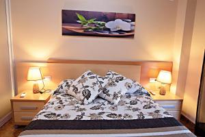Hostal Carrizo في إلدا: غرفة نوم بسرير ومخدات ومصباحين