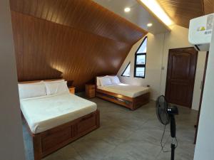 a bedroom with two beds and a fan at Annie's Lodge Agoo in Agoo