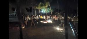 a group of people standing around a pool at night at Pousada do Sol in Aquiraz +57 photos