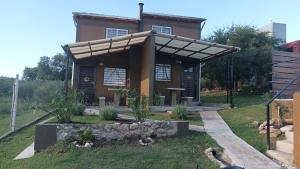 a building with awning in front of a yard at Cabañas El Molle in Cavalango