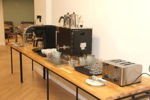 a counter with a coffee maker and glasses on it at Linza Suite in Babaeski