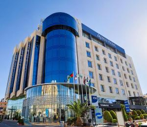 a large blue building with a glass facade at Ayass Hotel in Amman