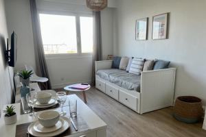 a living room with a couch and a table at L'escapade Sweet home - vue sur Mer et Dragon de Calais in Calais
