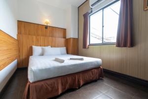 a bedroom with a large bed with a window at Sipadan Inn 1 in Semporna