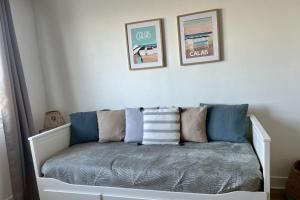 a bench with pillows on it in a room at L'escapade Sweet home - vue sur Mer et Dragon de Calais in Calais +20 photos