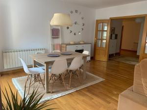 a dining room table and chairs in a living room at El Balcón de la Encina in Ponferrada