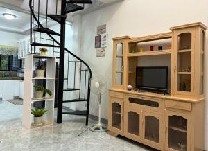 a living room with a tv and a staircase at Nielo's Apartment Door 4 in Dapitan