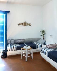 a bedroom with two beds and a fish on the wall at White Blue Villa formerly Ippocampi in Koutouloufari