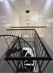a spiral staircase with a chandelier at Nielo's Apartment Door 4 in Dapitan