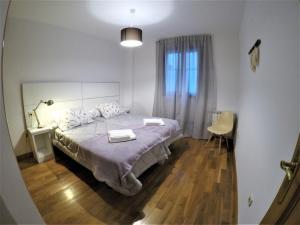 a bedroom with a bed with two towels on it at El Balcón de la Encina in Ponferrada