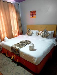 a hotel room with two beds and a window at Maple inn & Resort in Nairobi