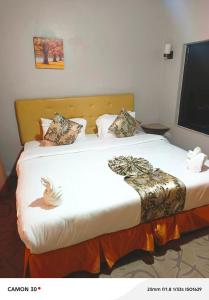 a bed in a hotel room with two pillows on it at Maple inn & Resort in Nairobi