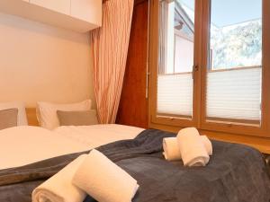 a bedroom with two beds and a large window at Nendaz Alpine Studio - Ski & Swimming Pool in Nendaz +12 photos