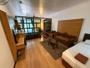 a hotel room with a bed and a living room at Sipadan Inn 1 in Semporna