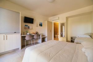 a bedroom with a large white bed and a desk at Crystal Camere in Marcelli