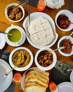 a table with plates of food and bowls of food at Dream villa in Imaduwa