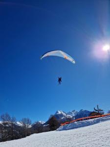 a person riding a parachute in the snow at PatRoch in Briançon