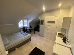 a bedroom with a bed and a desk in a room at Pokoje na wynajem w Willi in Warsaw