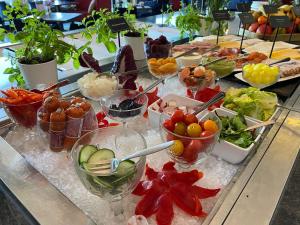 a buffet with many bowls of food on a table at Grand Hotel Amrâth Kurhaus The Hague Scheveningen in Scheveningen
