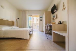 a bedroom with a bed and a desk and a kitchen at Crystal Camere in Marcelli