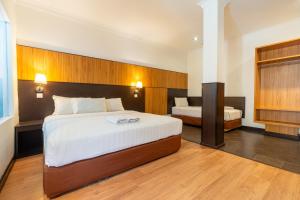 a bedroom with a large bed and two beds sidx sidx sidx at Sipadan Inn 1 in Semporna +4 photos
